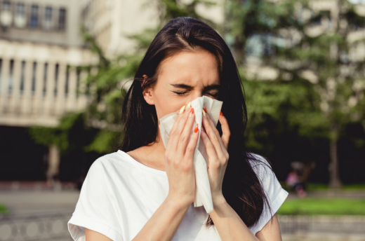 woman sneezing into tissue